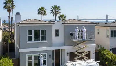 Professional house painter working on residential exterior in San Diego, CA