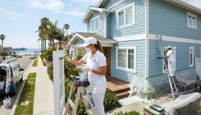 Professional house painters in San Diego CA applying exterior paint to a modern home façade